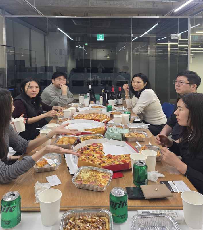 IDAC 미래포럼 참석자들이 피자와 함께 네트워킹하는 단체사진
